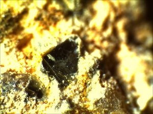 There is a piece of biotite on the surface of the felspar